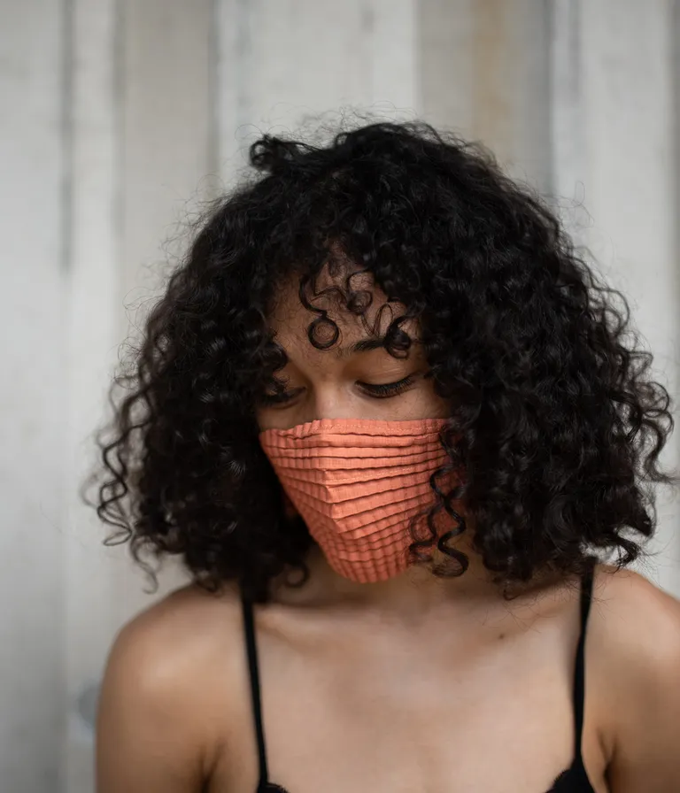 Woman wearing a peach face mask