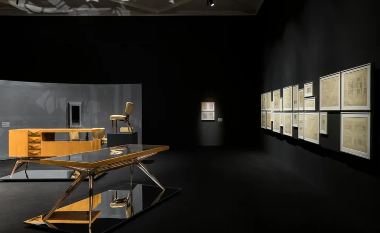 Dark interior of Triennale Design Museum with furniture and sketches by Carlo Mollino