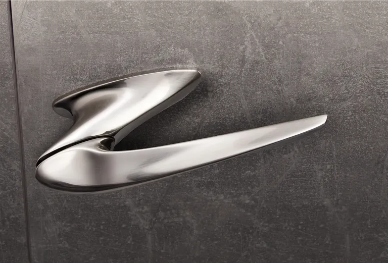 Design Door Handle by Zaha Hadid with sinuous forms in metal on a concrete-like background